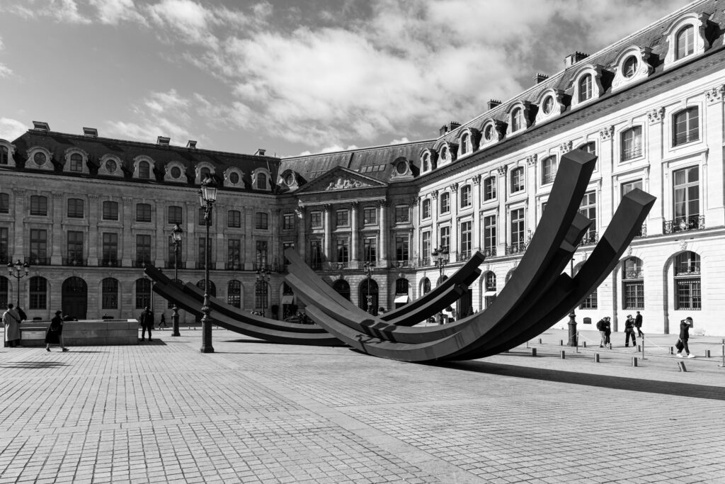 Modern sculpture in a Parisian square surrounded by classic architecture.