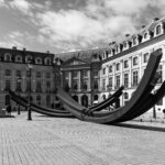 Modern sculpture in a Parisian square surrounded by classic architecture.